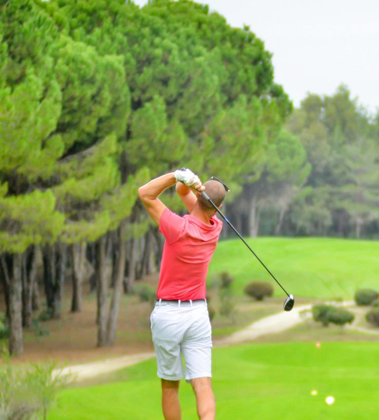 Man swinging a gold club on a green fairway